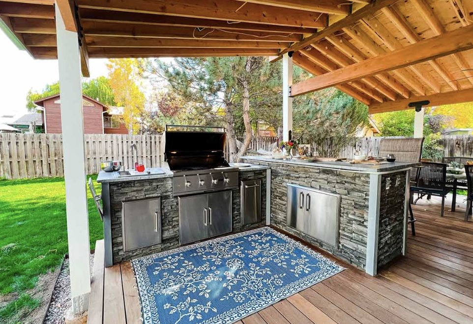 Community outdoor kitchen with stainless grill and artificial turf at an apartment courtyard