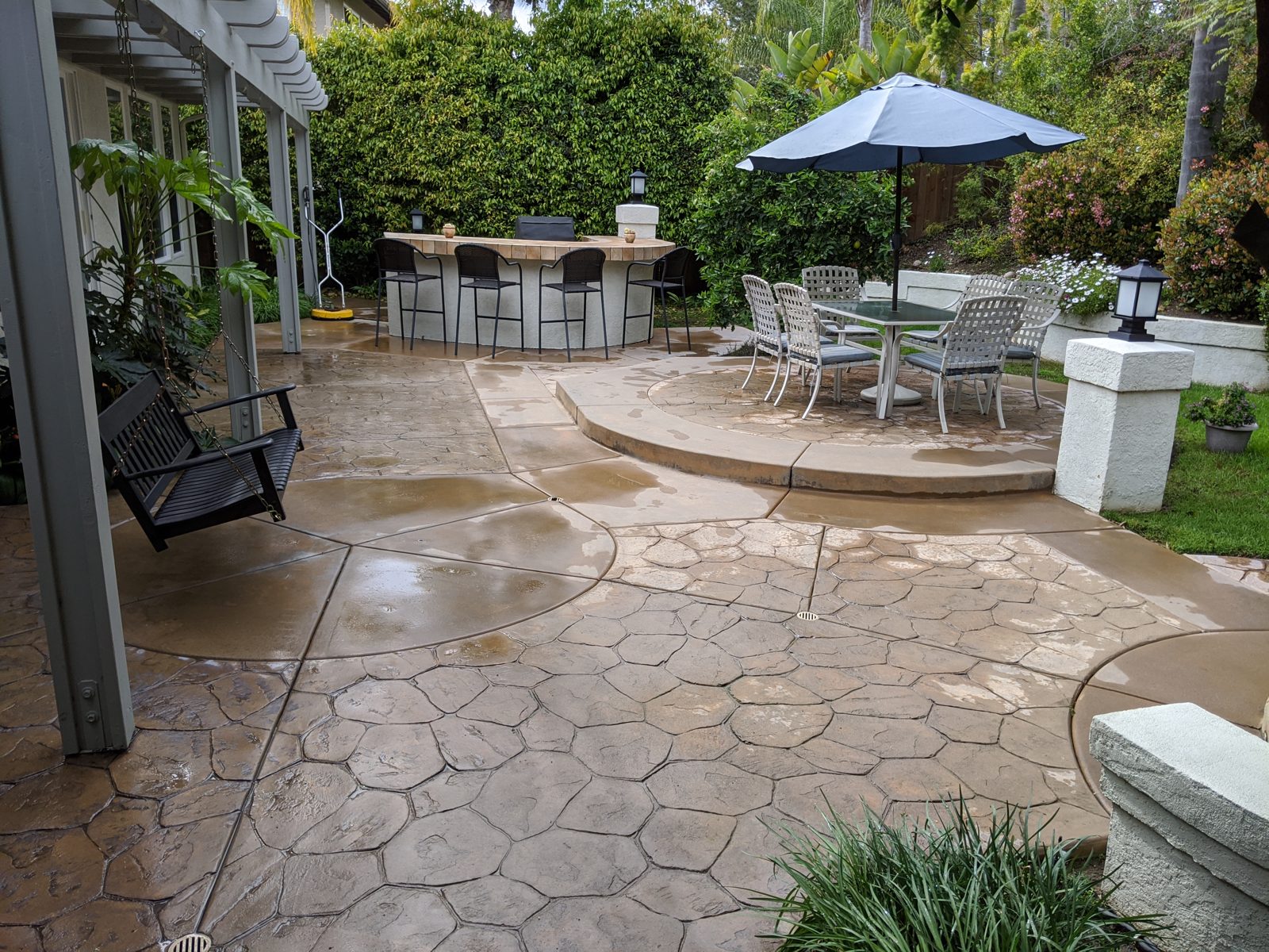 Freshly cleaned stamped concrete patio with outdoor dining set