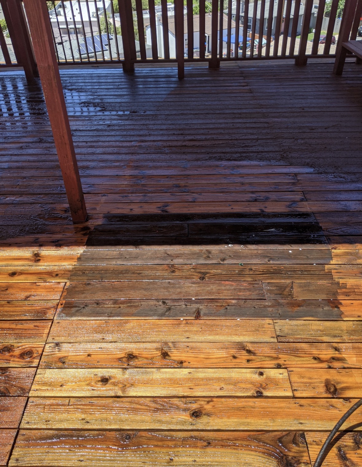Wood deck restoration in progress showing cleaned boards and weathered areas at a San Diego hillside home