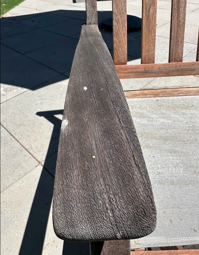 Close view of the weathered teak chair arm before PatioMaid restoration in San Diego
